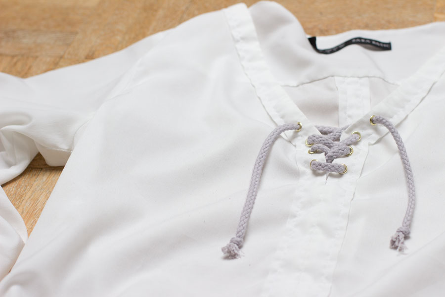 Do you have an old blouse in your closet? Follow this easy refashion tutorial for a DIY lace up blouse and wear it all summer long!